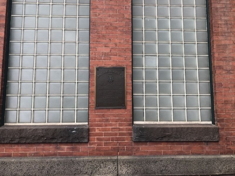 The memorial plaque between the glass-block windows
