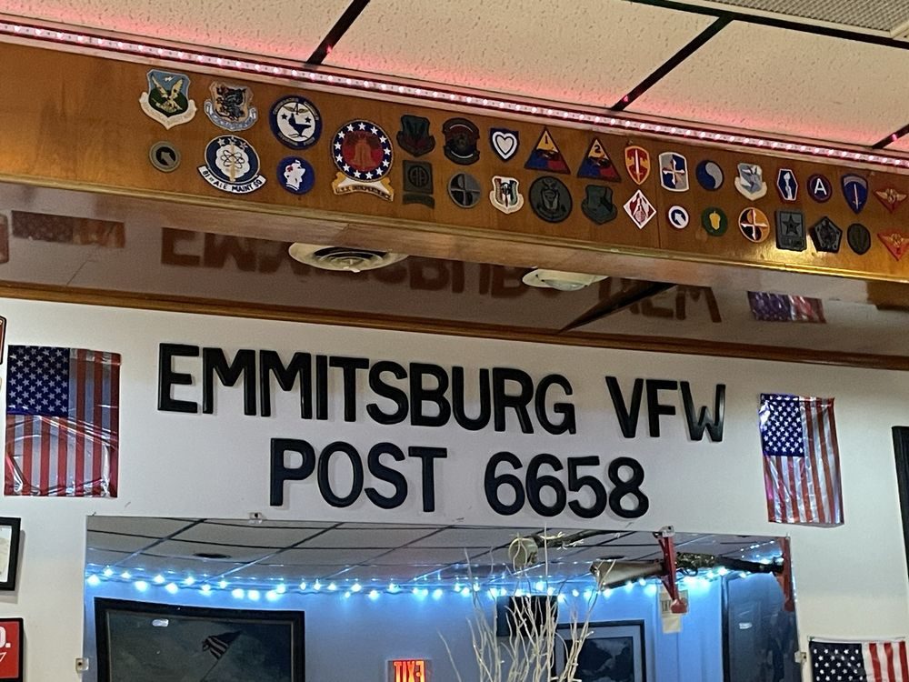 The sign wall inside the Post reading EMMITSBURG VFW POST 6658, lined with military unit patches